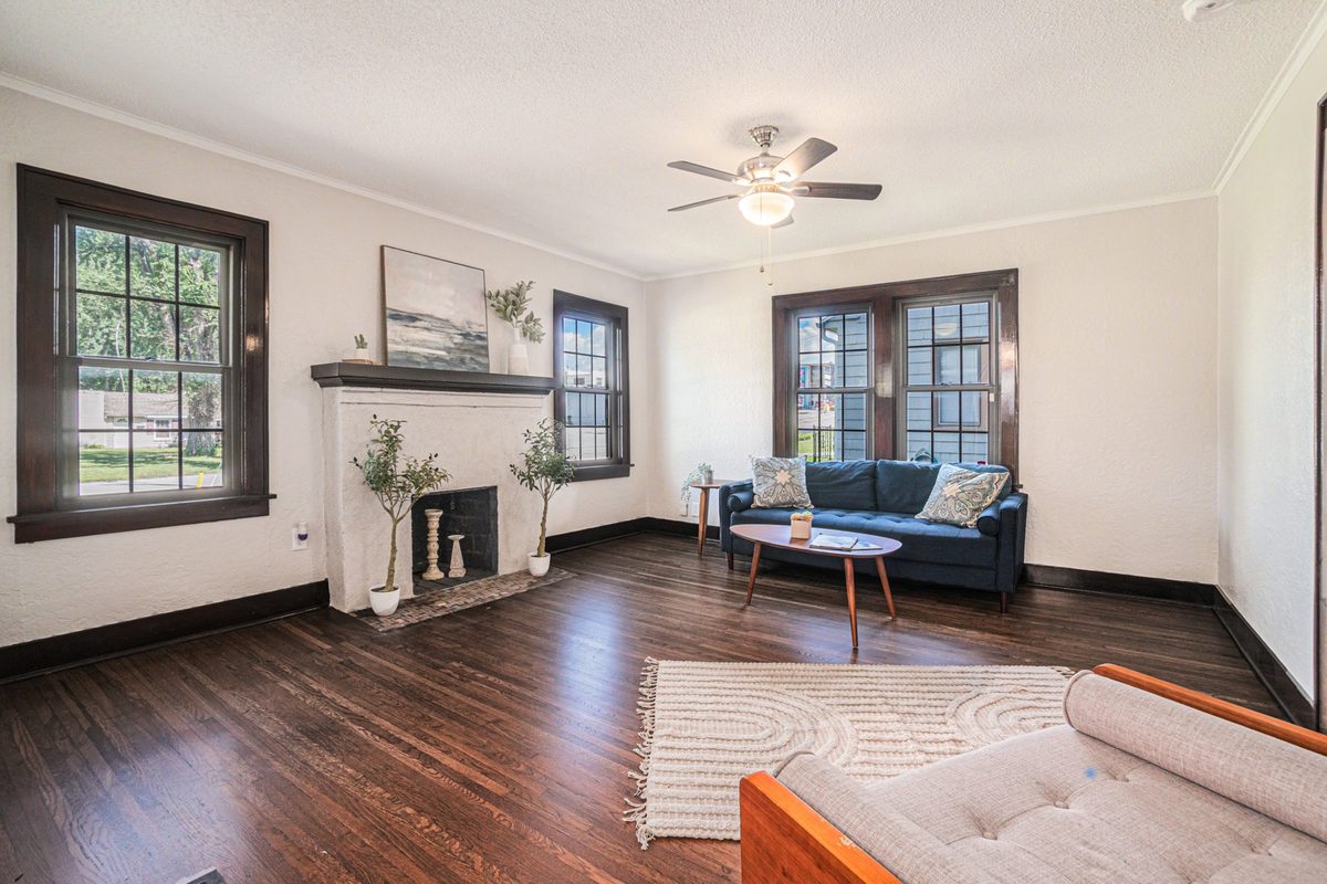 After: bright staged living room with a refreshed brick fireplace and mid-century furnishings