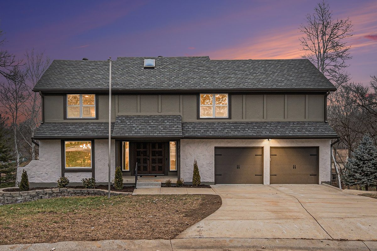 After: home exterior photographed at twilight with warm window light
