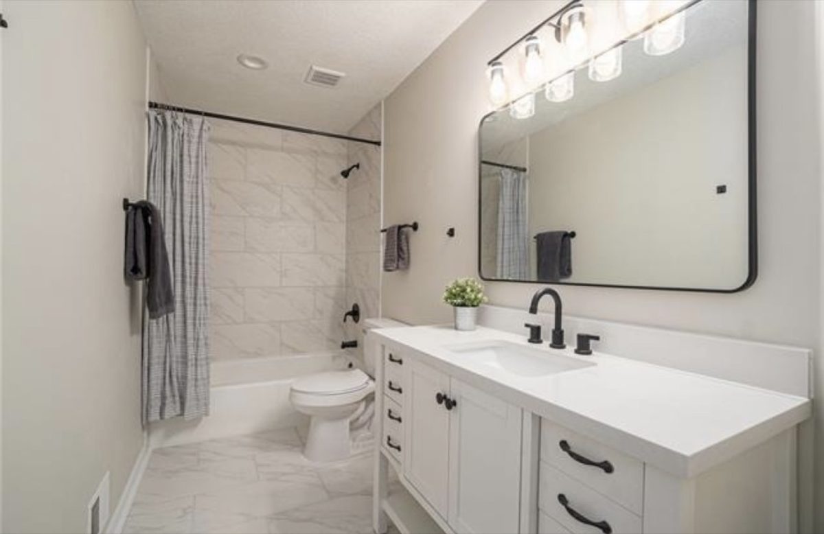 After: modern primary bath with clean tile, glass shower, and a double vanity