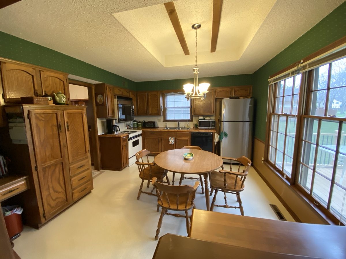 Before: enclosed kitchen with dark cabinets and dated countertops