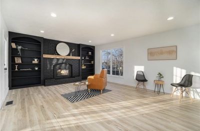 After: living room with a black fireplace, built-ins, and airy staging
