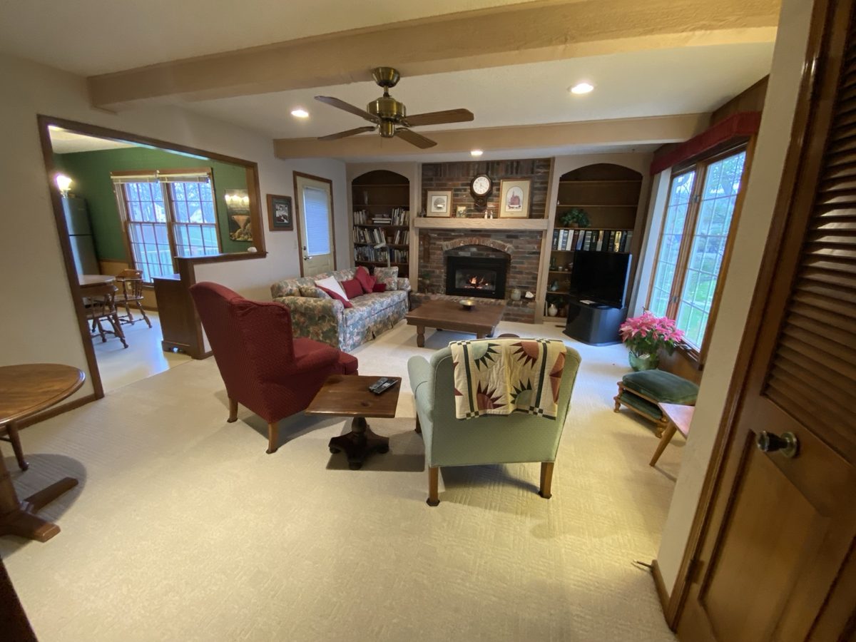 Before: living room with a dated red-brick fireplace and heavy furniture