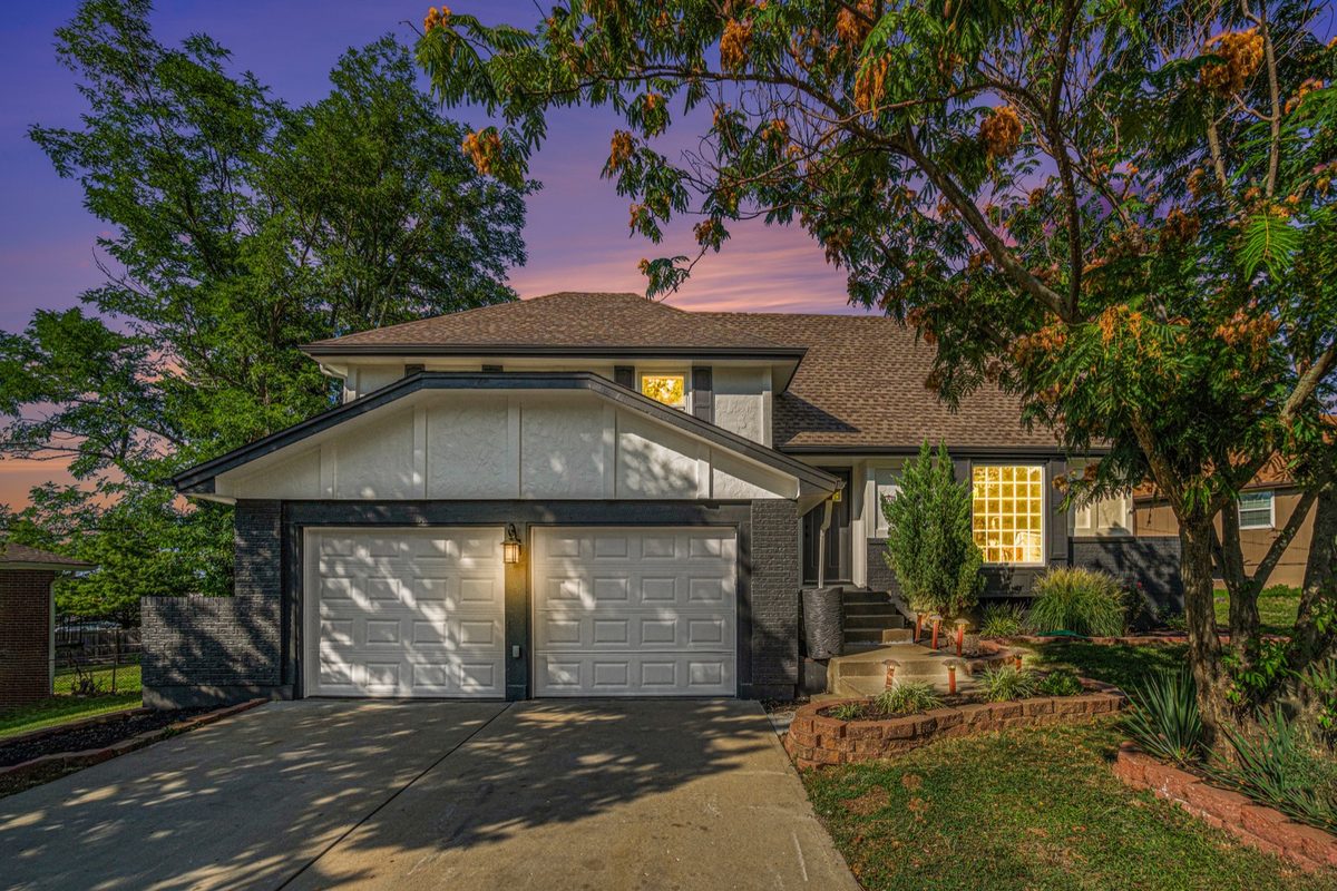 After: home exterior photographed at twilight with warm window light